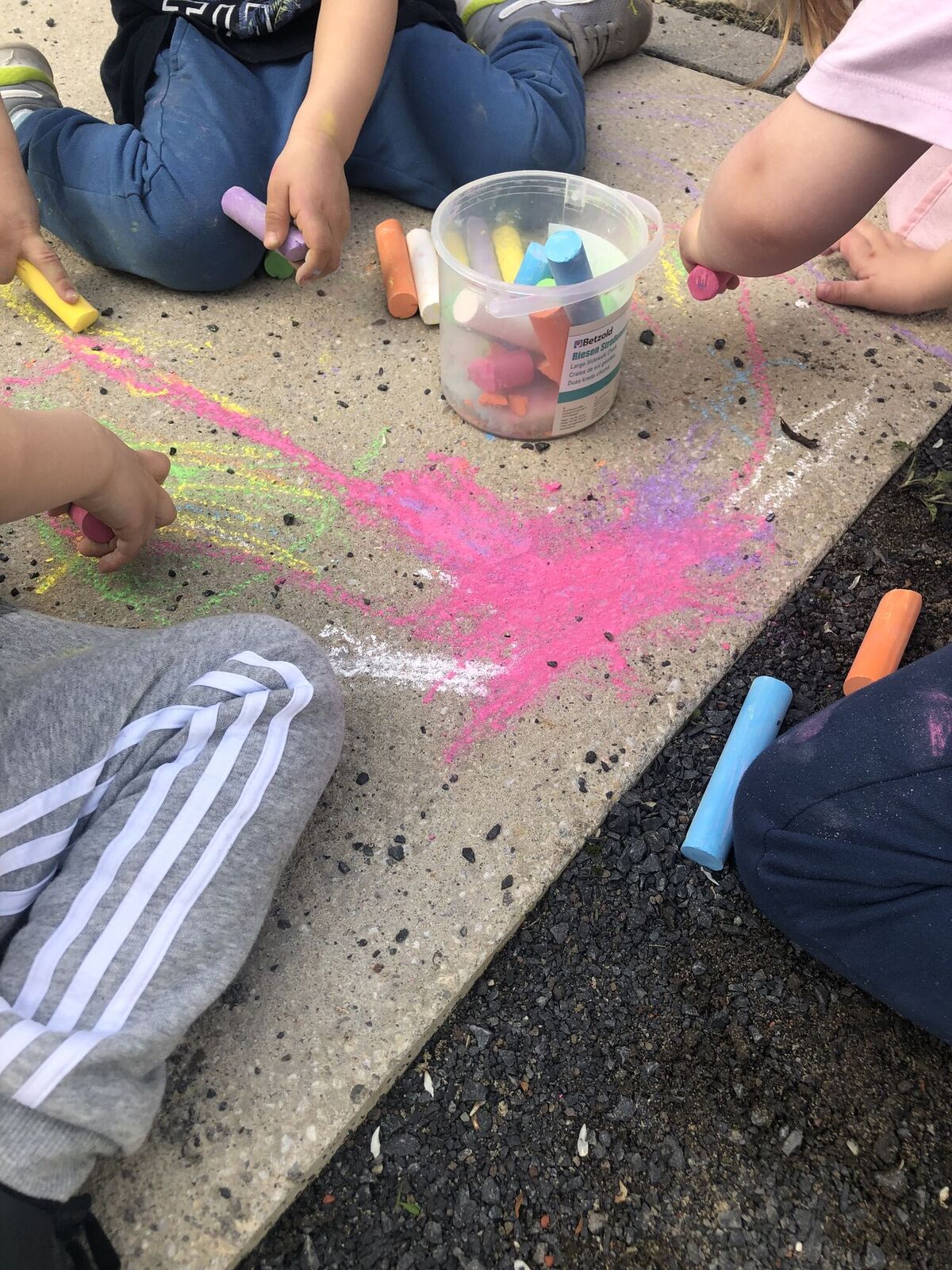 Kinder malen mit Straßenkreide